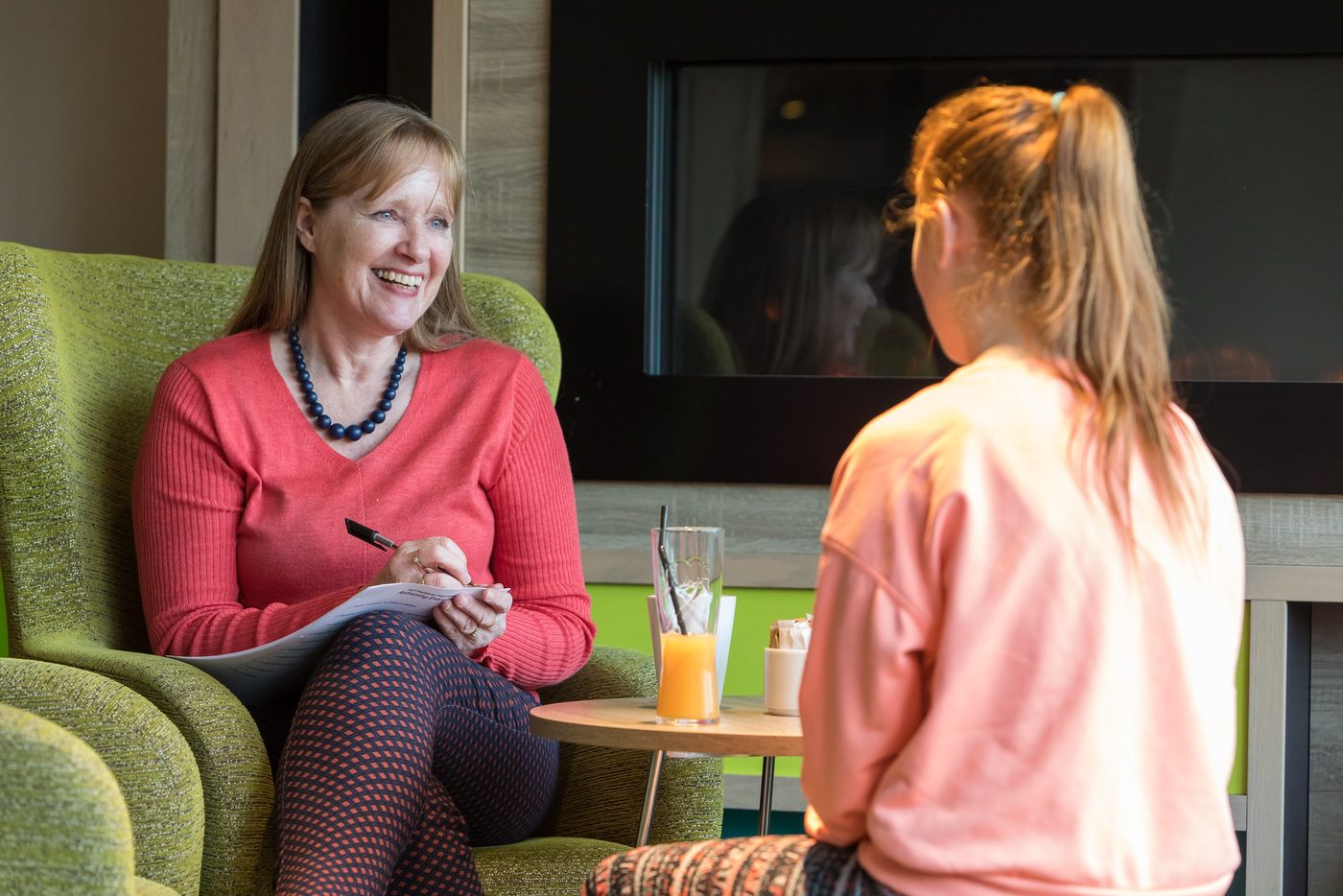 Jackie Johnson smiling and talking with a young client during a session